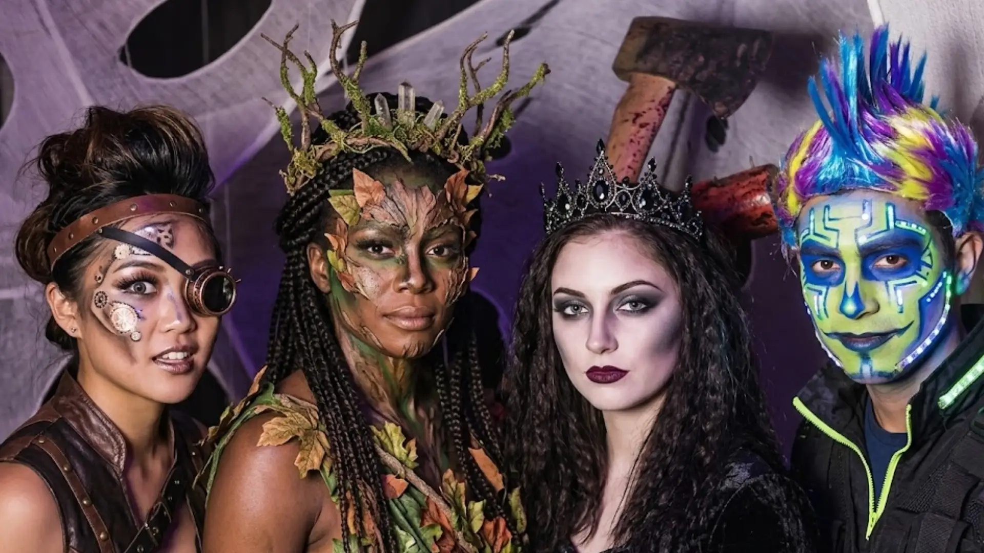 Four people in creative costumes with face paint posing together at themed party with fantasy and sci fi styling