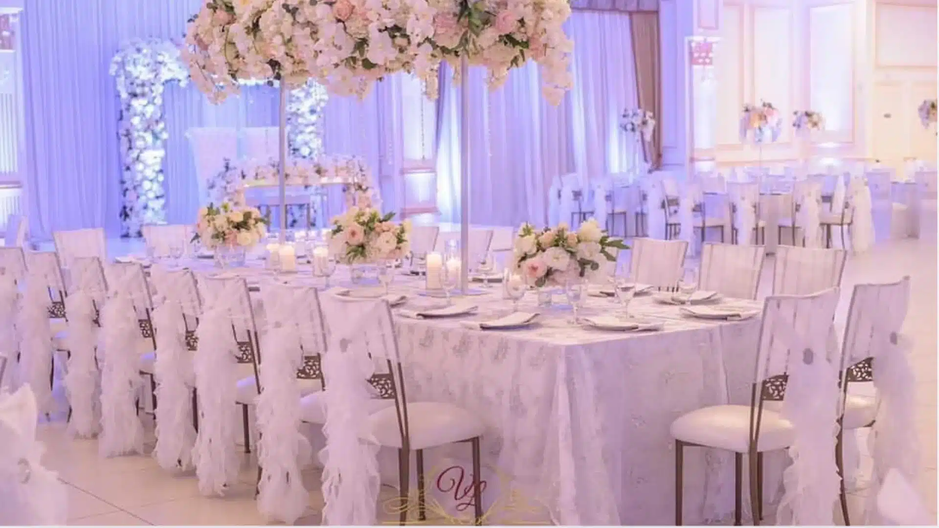 Elegant wedding reception setup with floral centerpieces candles and decorated banquet tables