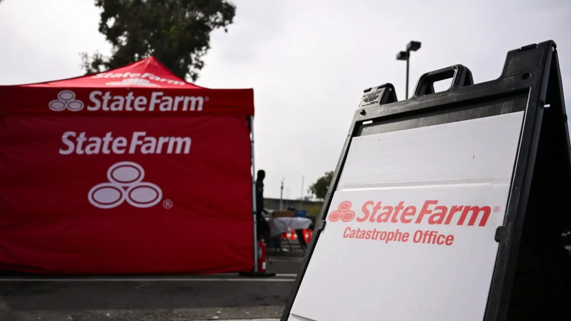 State Farm catastrophe office sign with red branded tent set up outdoors for insurance assistance services