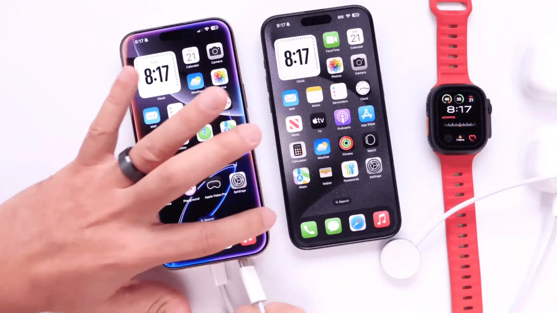 Two iPhones connected with cable next to Apple Watch and AirPods demonstrating charging setup