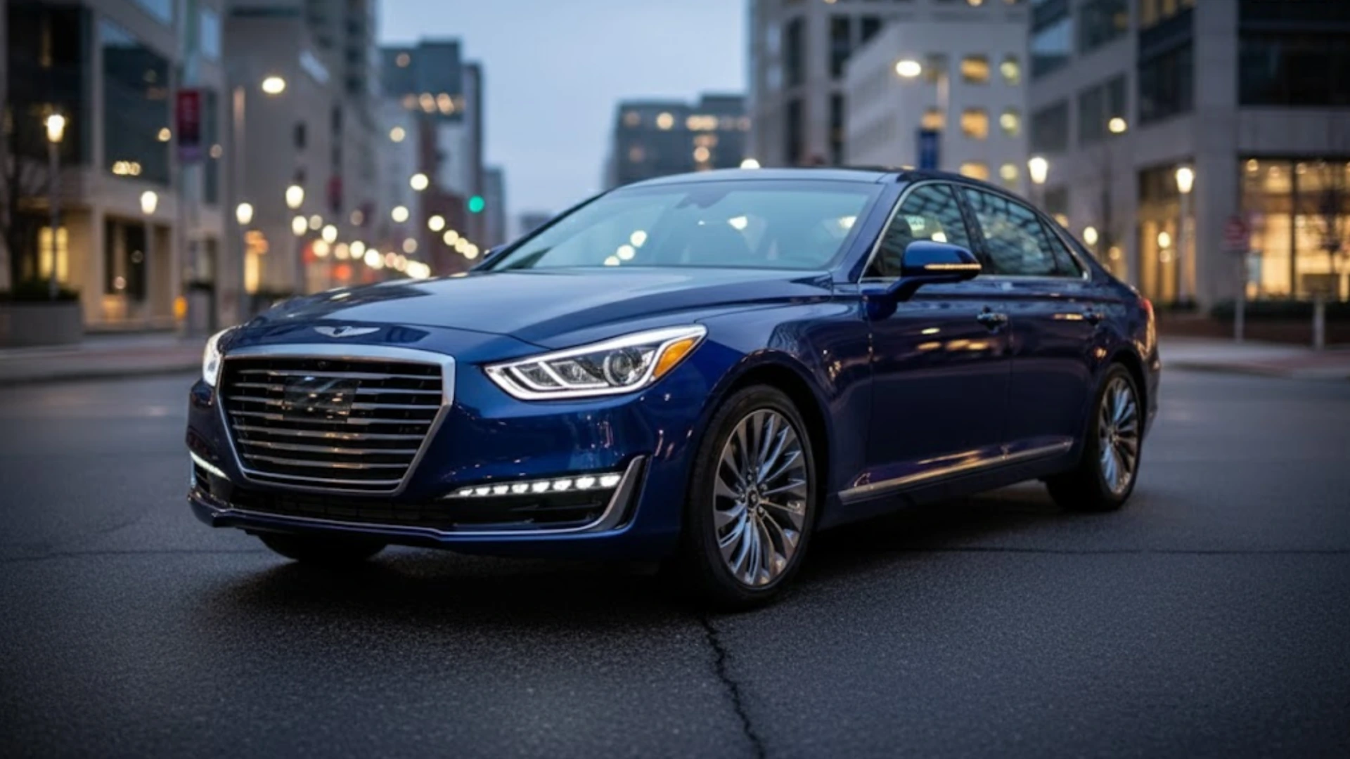 Blue Genesis luxury sedan parked on a city street at dusk with LED headlights on and modern buildings in background