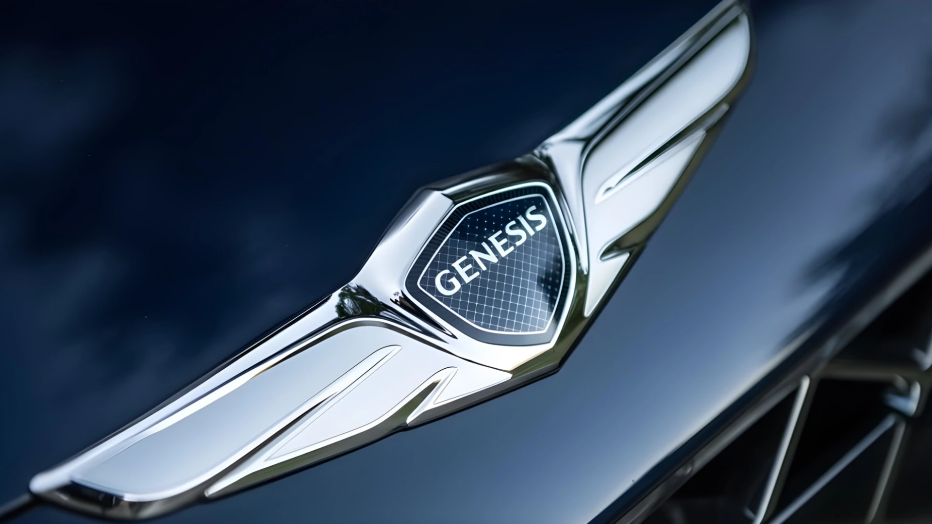 Close-up of Genesis luxury car emblem on a dark blue vehicle hood with chrome wings and sleek design details