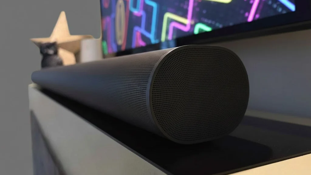 Close up of Sonos Arc Ultra soundbar placed under a TV on a media console with modern decor in background