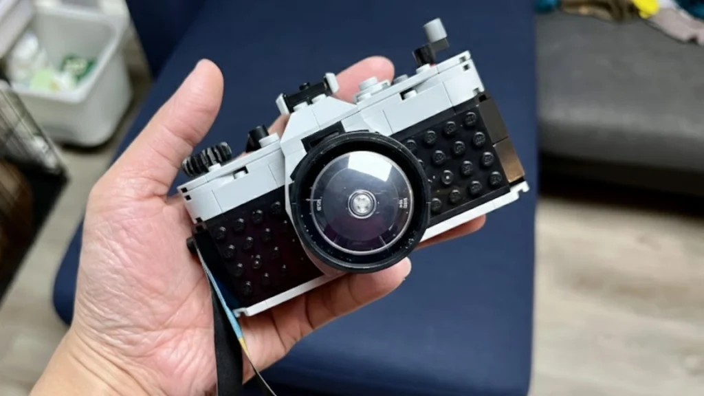 Fujifilm X100VI style compact camera held in hand, showing retro rangefinder design with fixed lens and classic controls