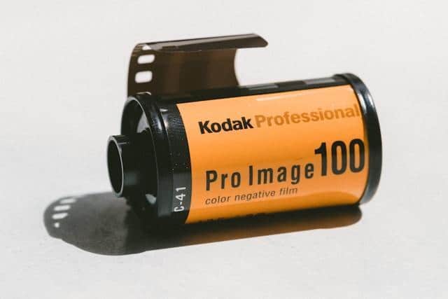 A roll of Kodak camera film on a white surface and background.