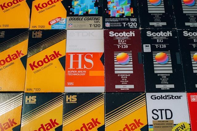 A row of different VHS tape boxes from various manufacturers.