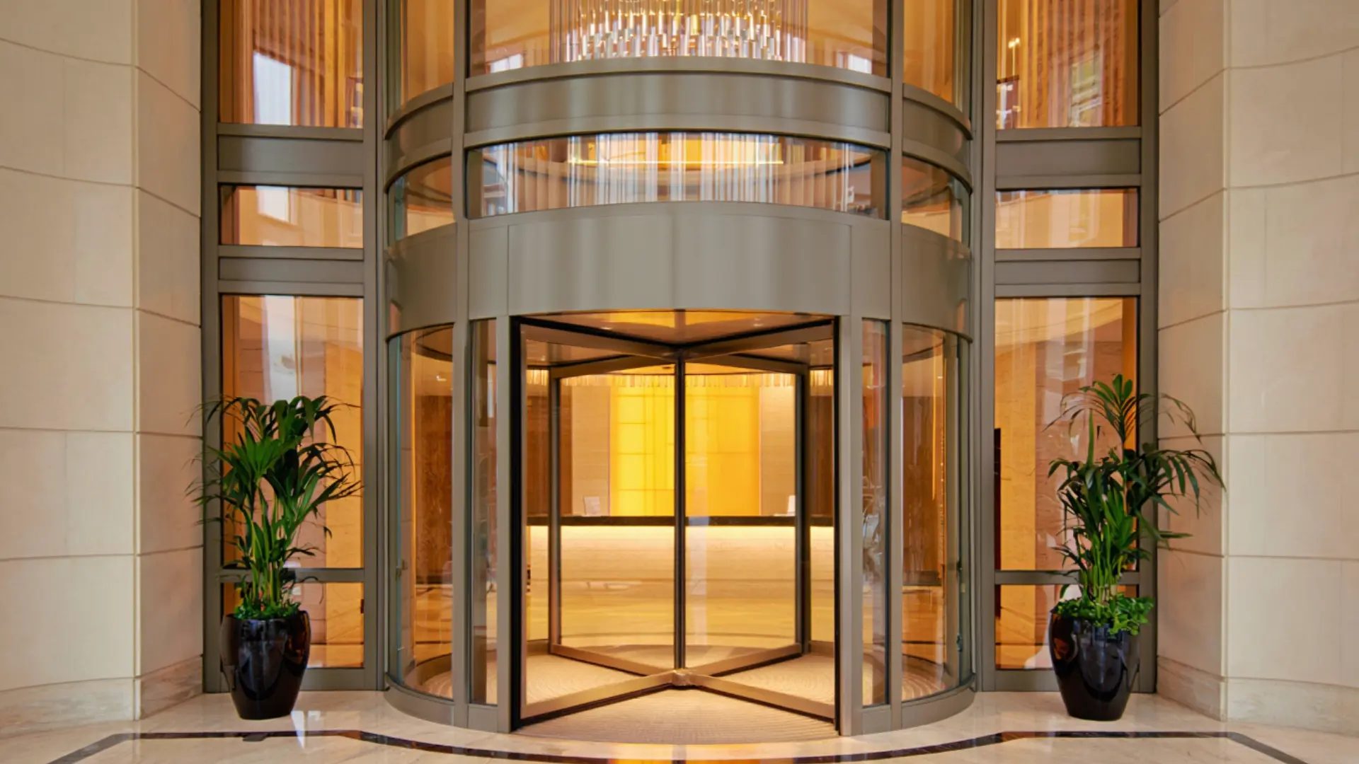 Automatic revolving door at modern hotel building entrance with glass panels and indoor lobby visible behind the door