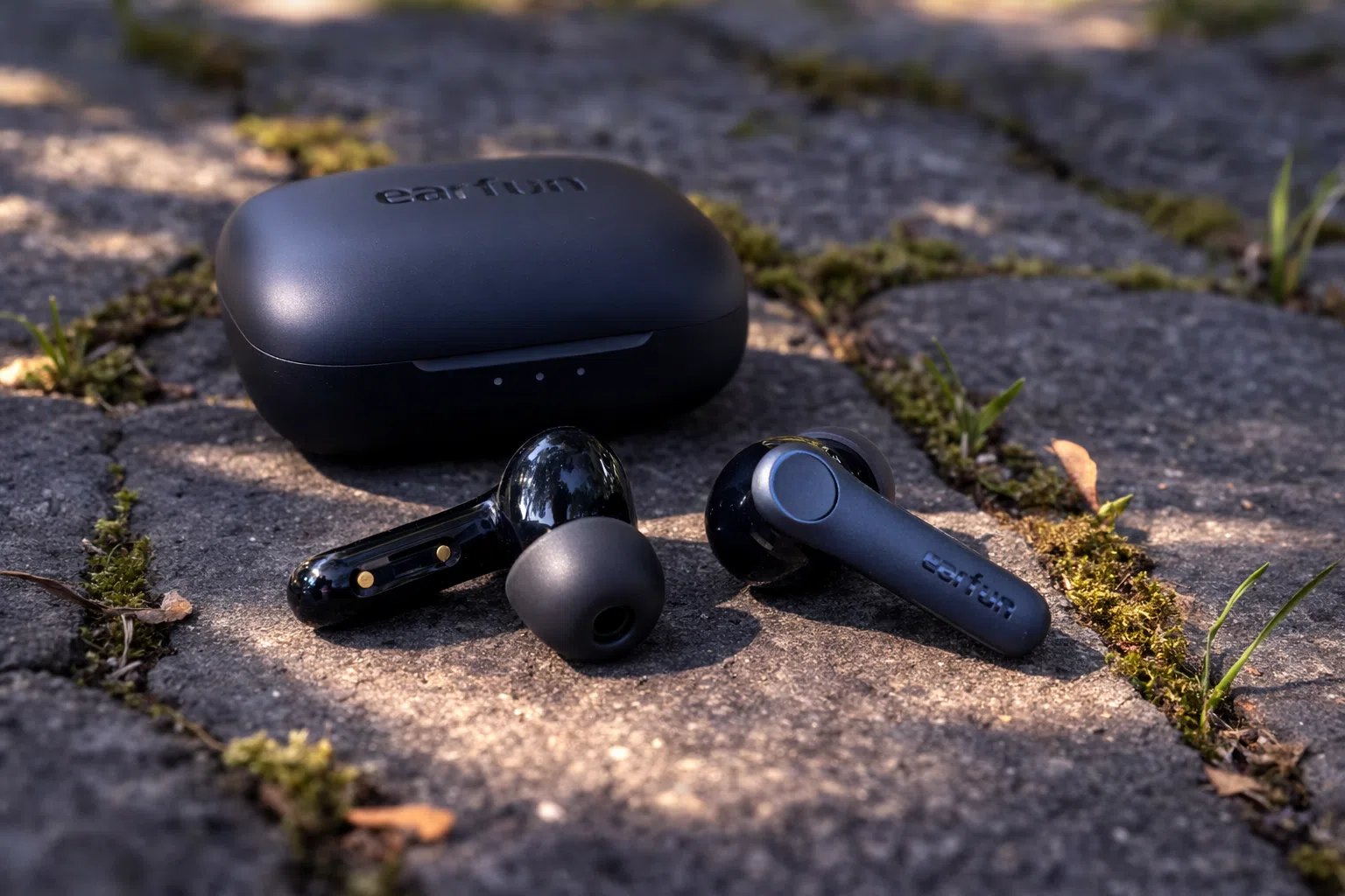 EarFun Air Pro 4 true wireless earbuds with charging case on outdoor stone surface