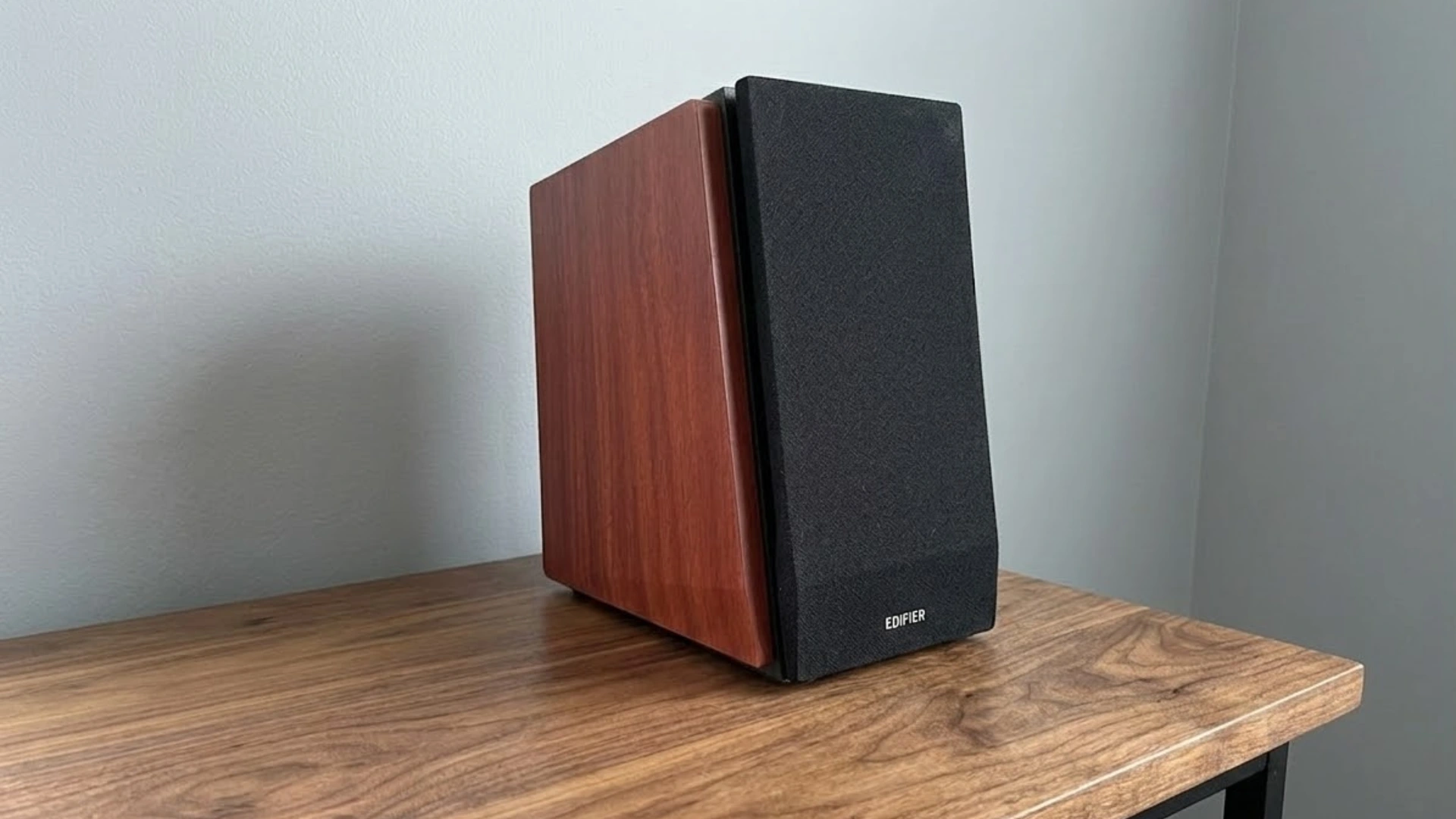 Edifier R1700BT bookshelf speaker with wooden cabinet placed on desk, showing compact home audio setup and classic speaker design