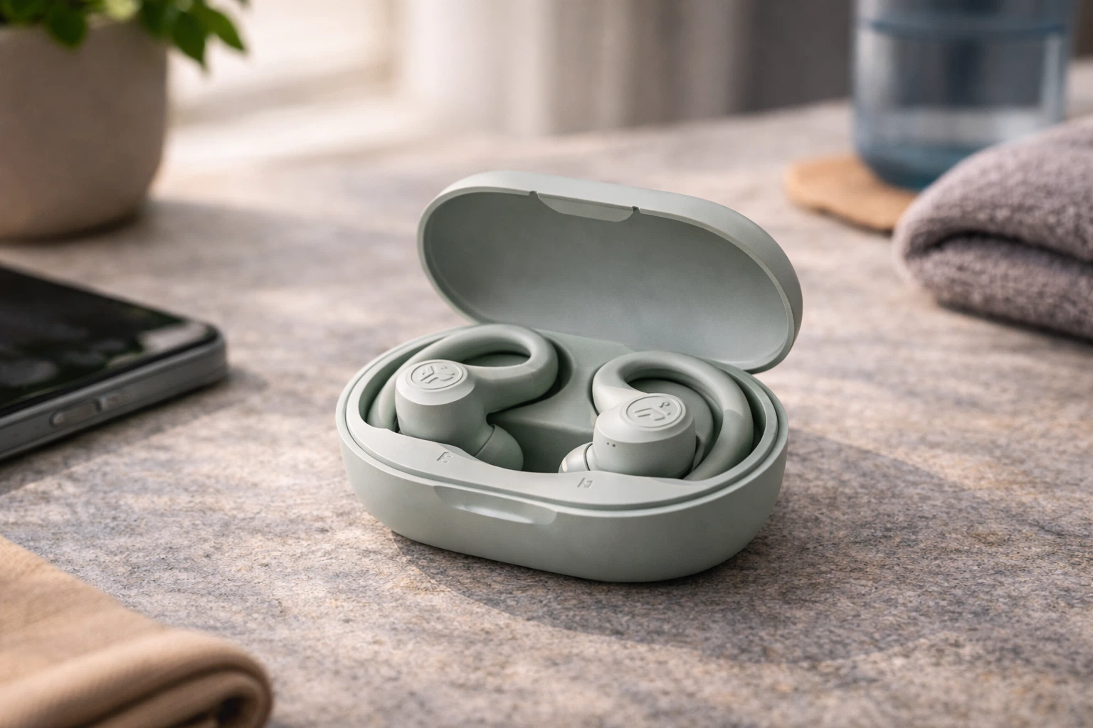 JLab Go Air Sport ANC earbuds in open green charging case on desk