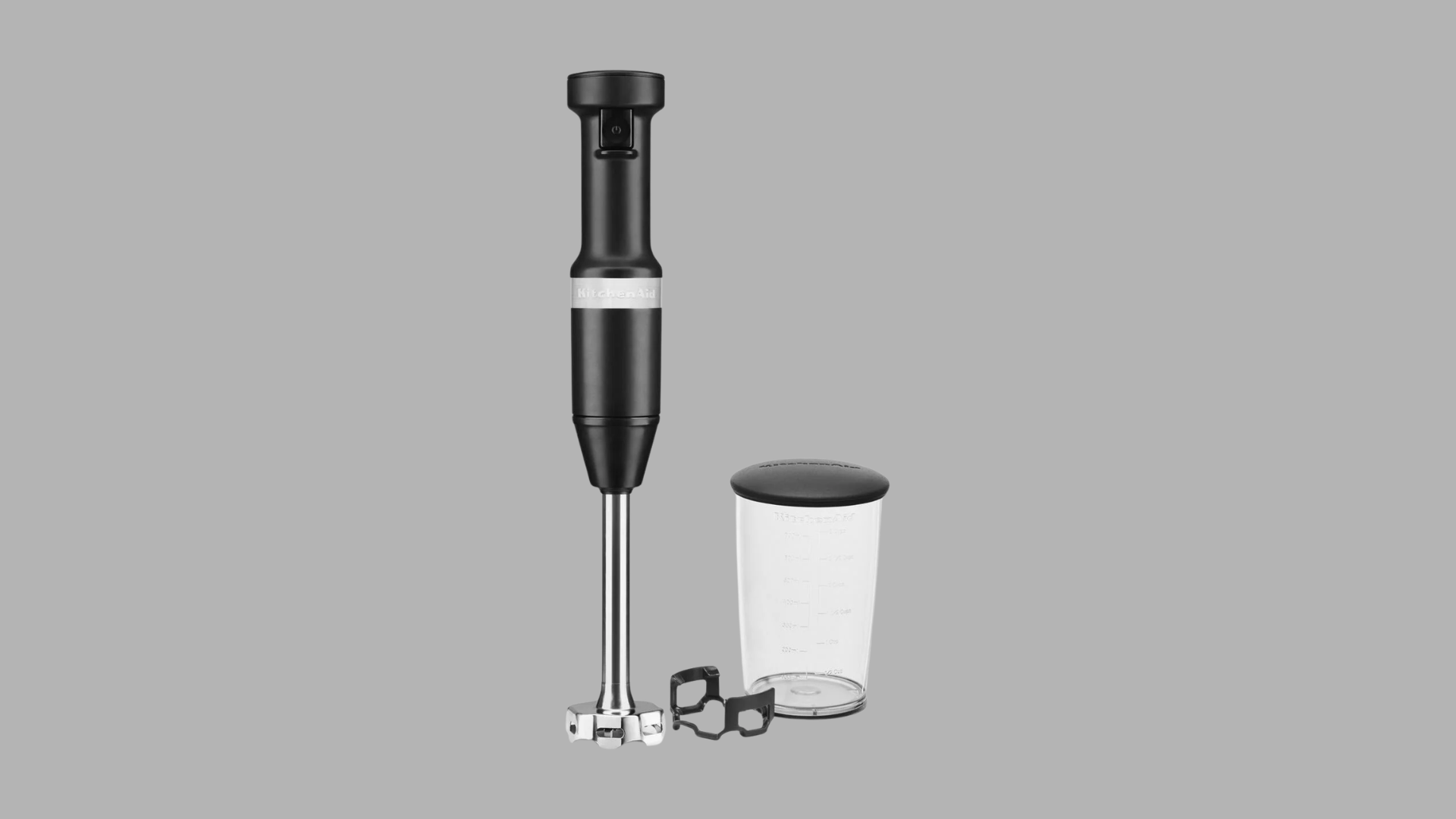 KitchenAid cordless hand blender with blending arm, blade guard, and measuring cup for easy mixing and pureeing