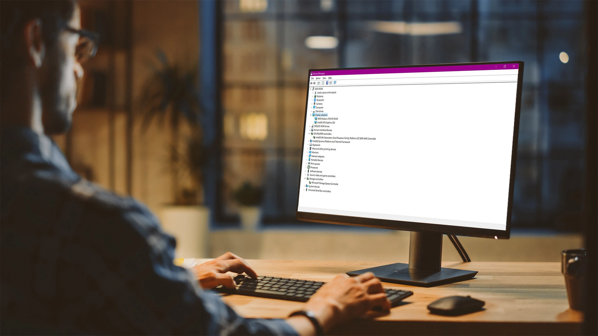 Man using Windows Device Manager on desktop computer to reset or refresh graphics card driver settings