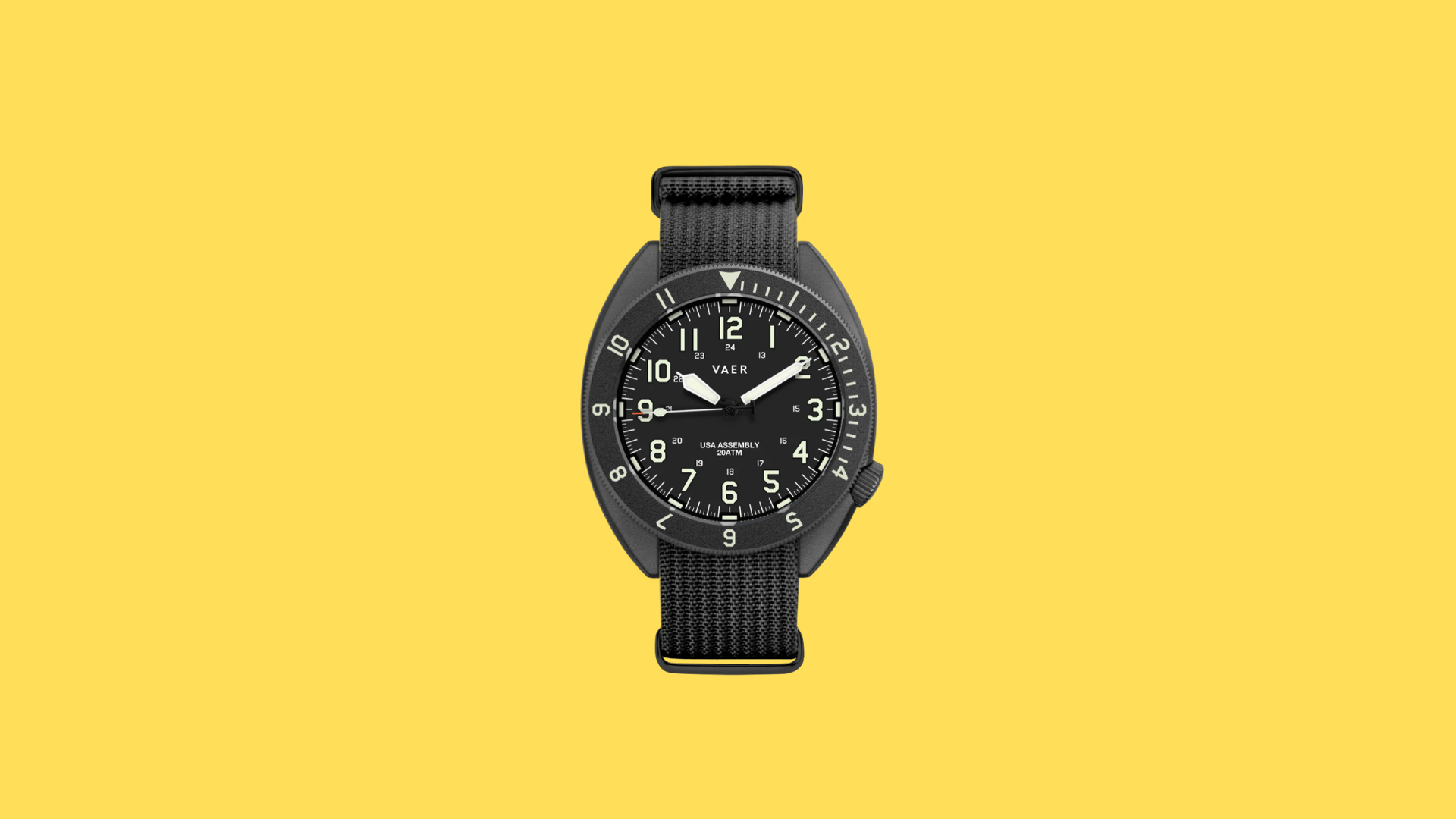 Vaer field watch with black dial, luminous Arabic numerals, rotating bezel, and black nylon strap on dark background