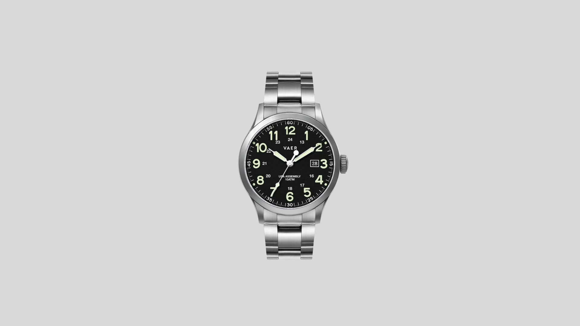 Vaer field watch with black dial, luminous numerals, date window, and stainless steel bracelet on a clean background