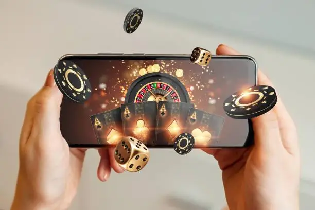 Person holding smartphone displaying virtual casino elements with dice, poker chips, and cards floating.