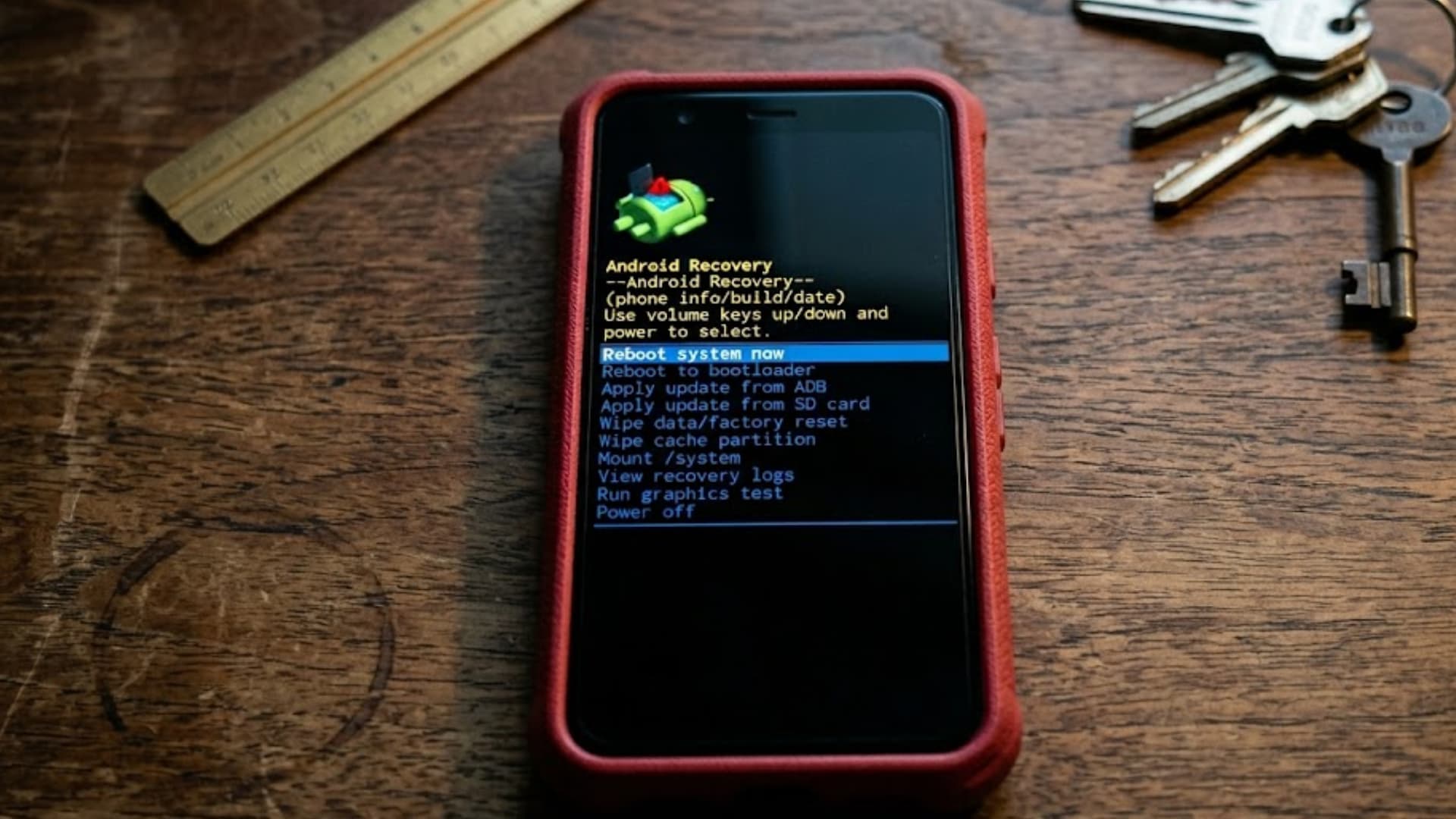 A close-up shot of a smartphone placed on a vintage surface, showing Android recovery mode on the screen