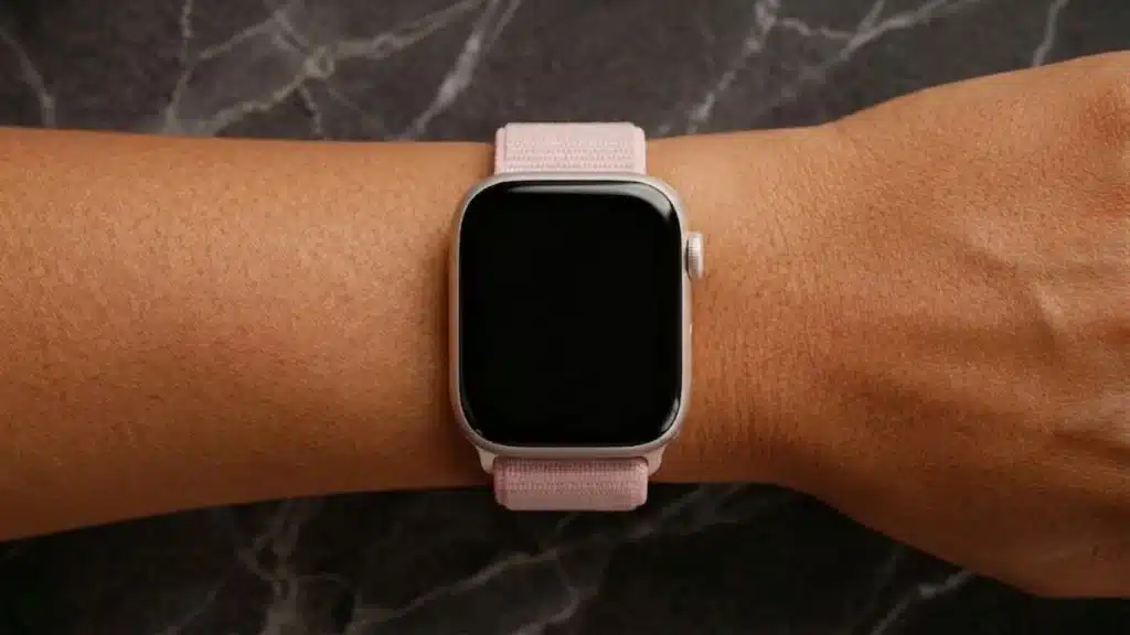 Apple Watch Series 9 on wrist with pink sport band showing minimal display and comfortable everyday fit