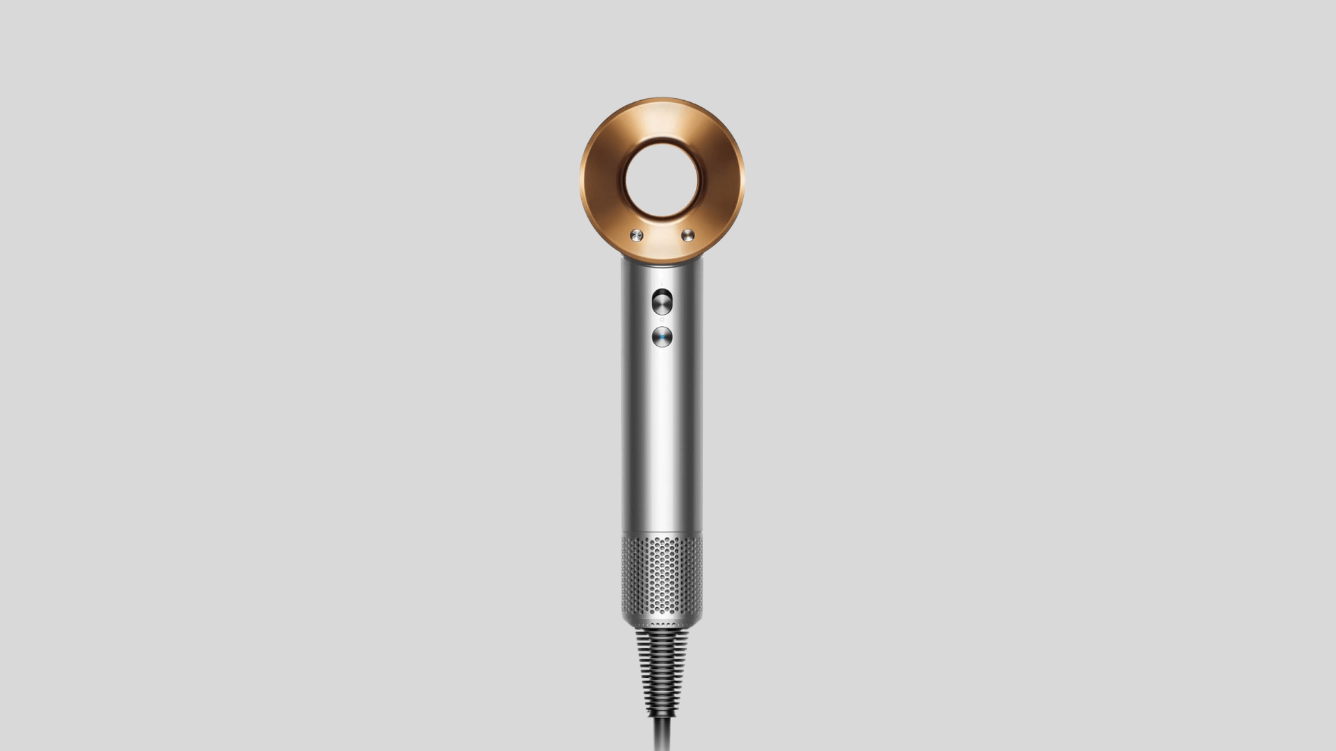 Dyson Supersonic hair dryer in silver and copper finish displayed on a grey background