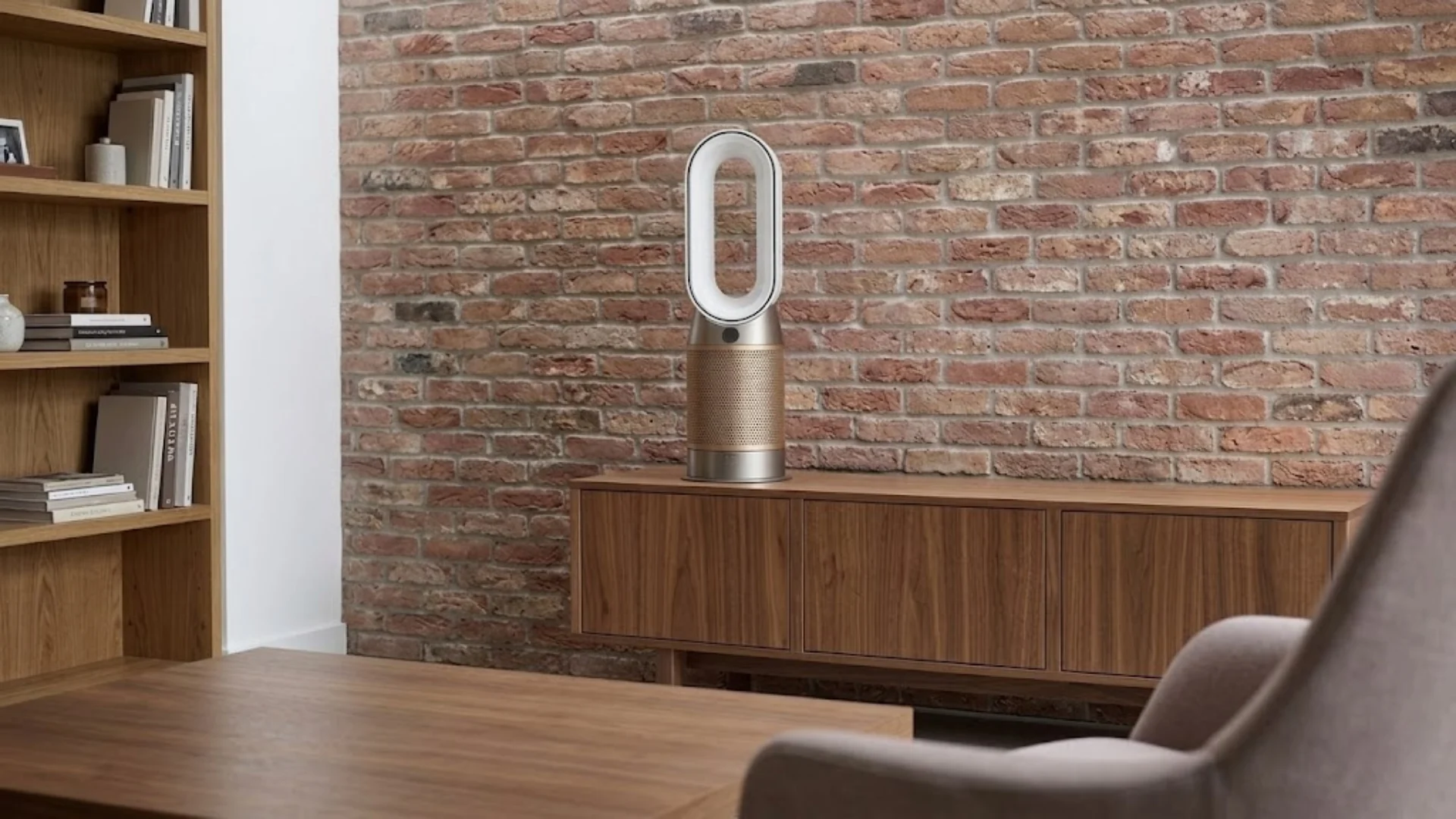 Dyson air purifier placed on wooden cabinet in a modern room with brick wall and minimalist furniture