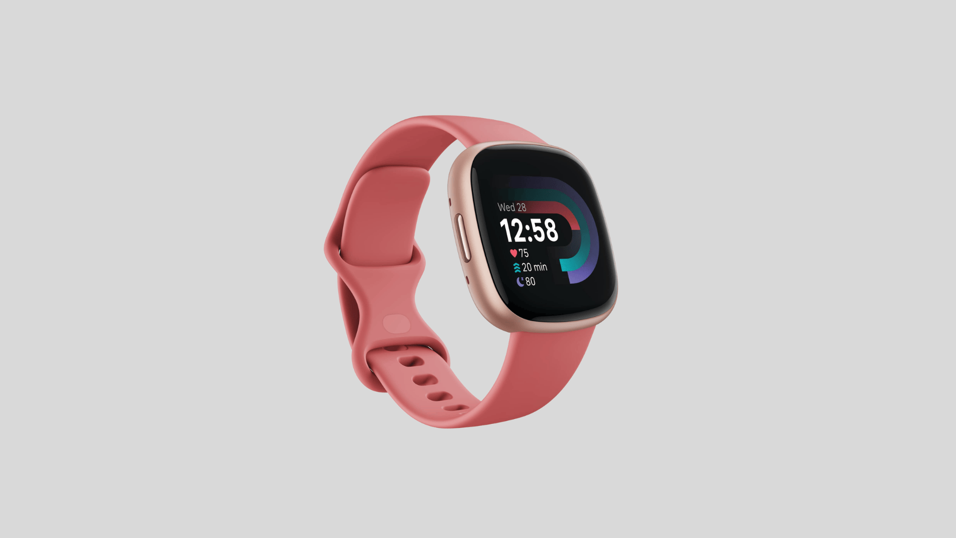 Fitbit Versa smartwatch with pink silicone band and square display showing time, heart rate and activity stats