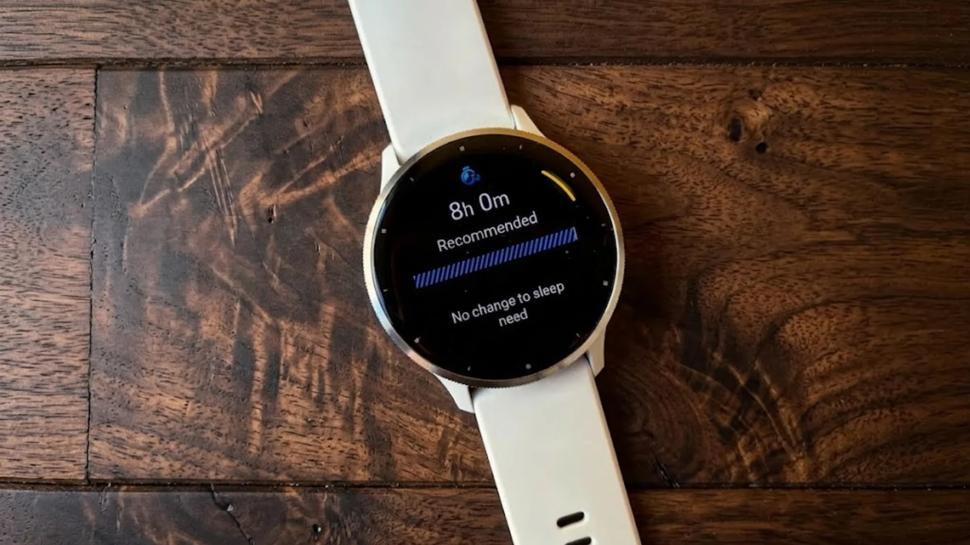 Garmin Venu 3 smartwatch showing sleep recommendation screen on AMOLED display placed on wooden surface