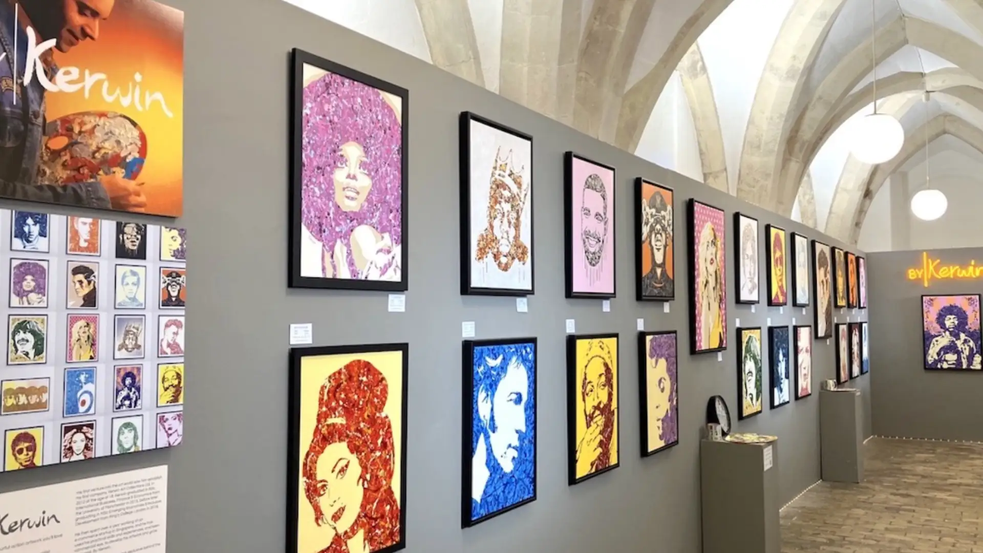 Art exhibition gallery displaying many colorful framed portraits on a wall in modern indoor space