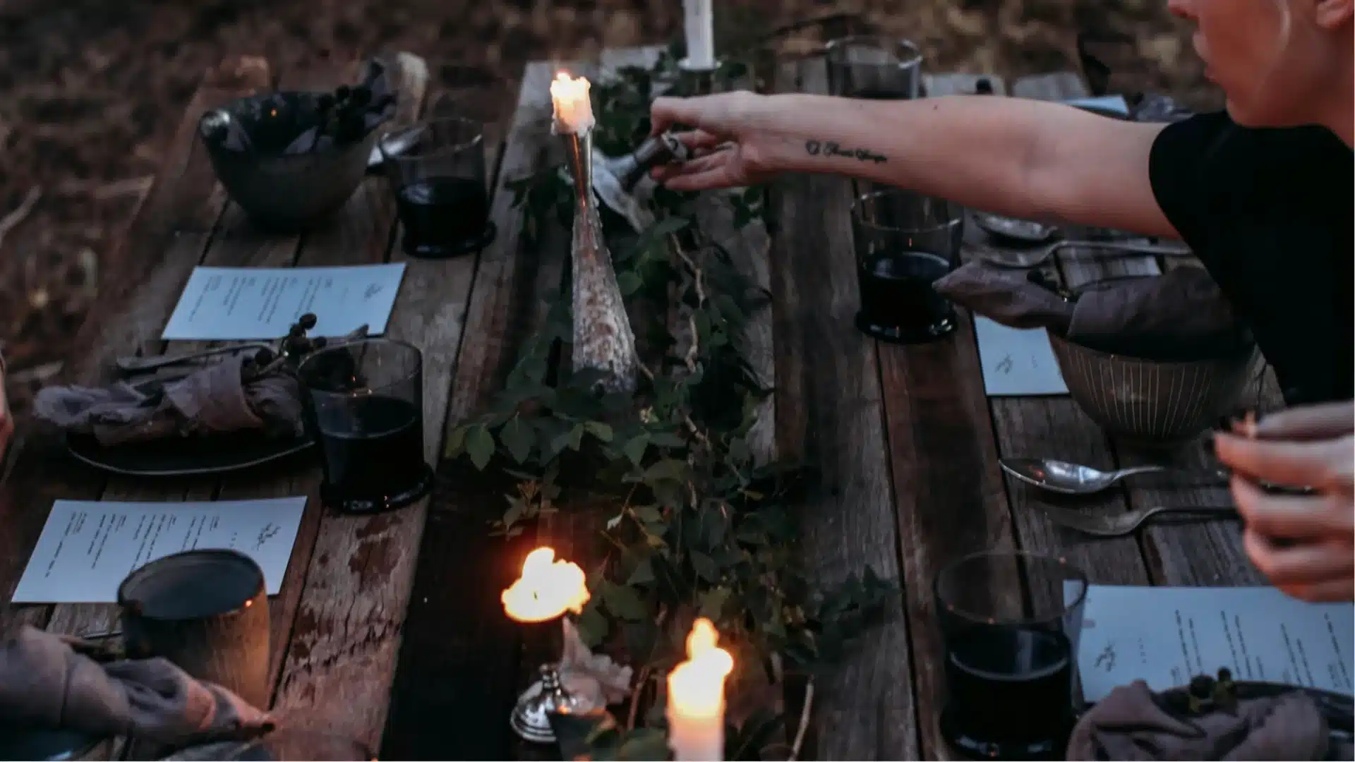 Candlelit dinner table with rustic decor, wine glasses, and intimate mystery themed dining experience