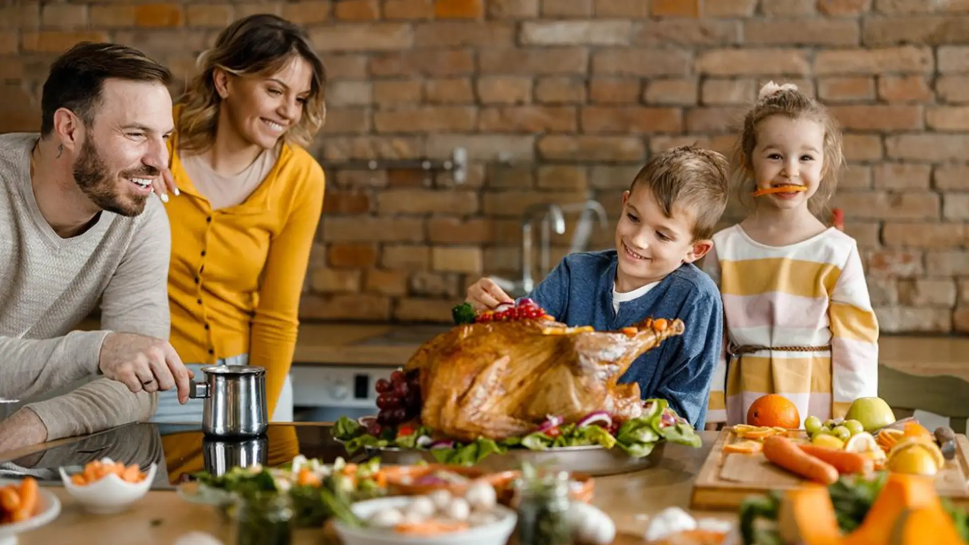Family smiling around roasted turkey dinner in kitchen, enjoying warm dine-out night style meal at home