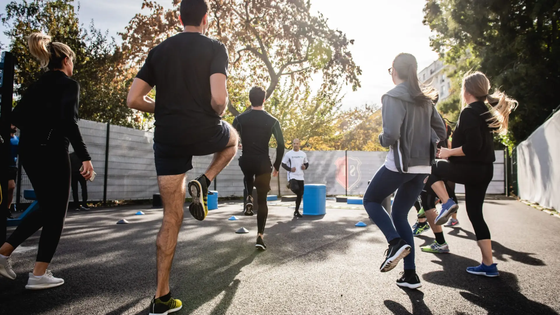 Group of people exercising outdoors during walkathon, jogging together on sunny day for school community event