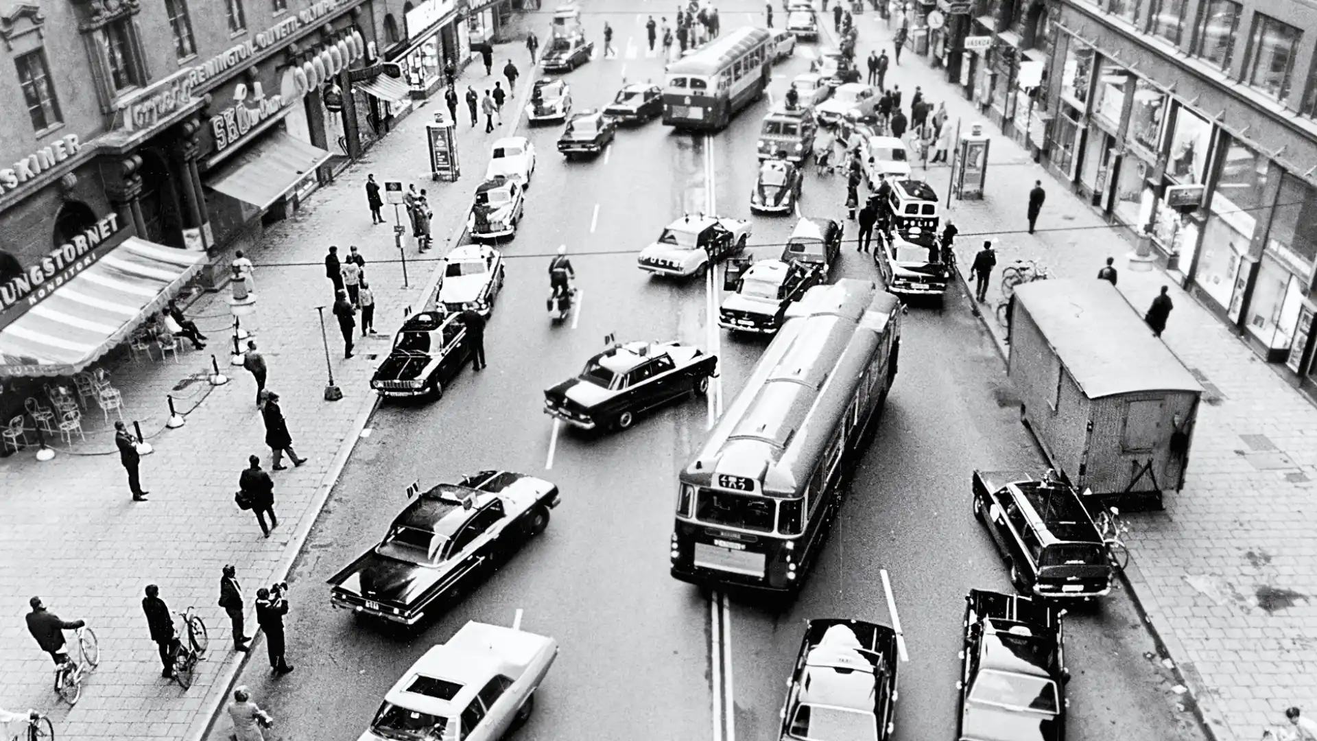 Aerial view of busy city street with cars and buses during traffic confusion as people gather on sidewalks