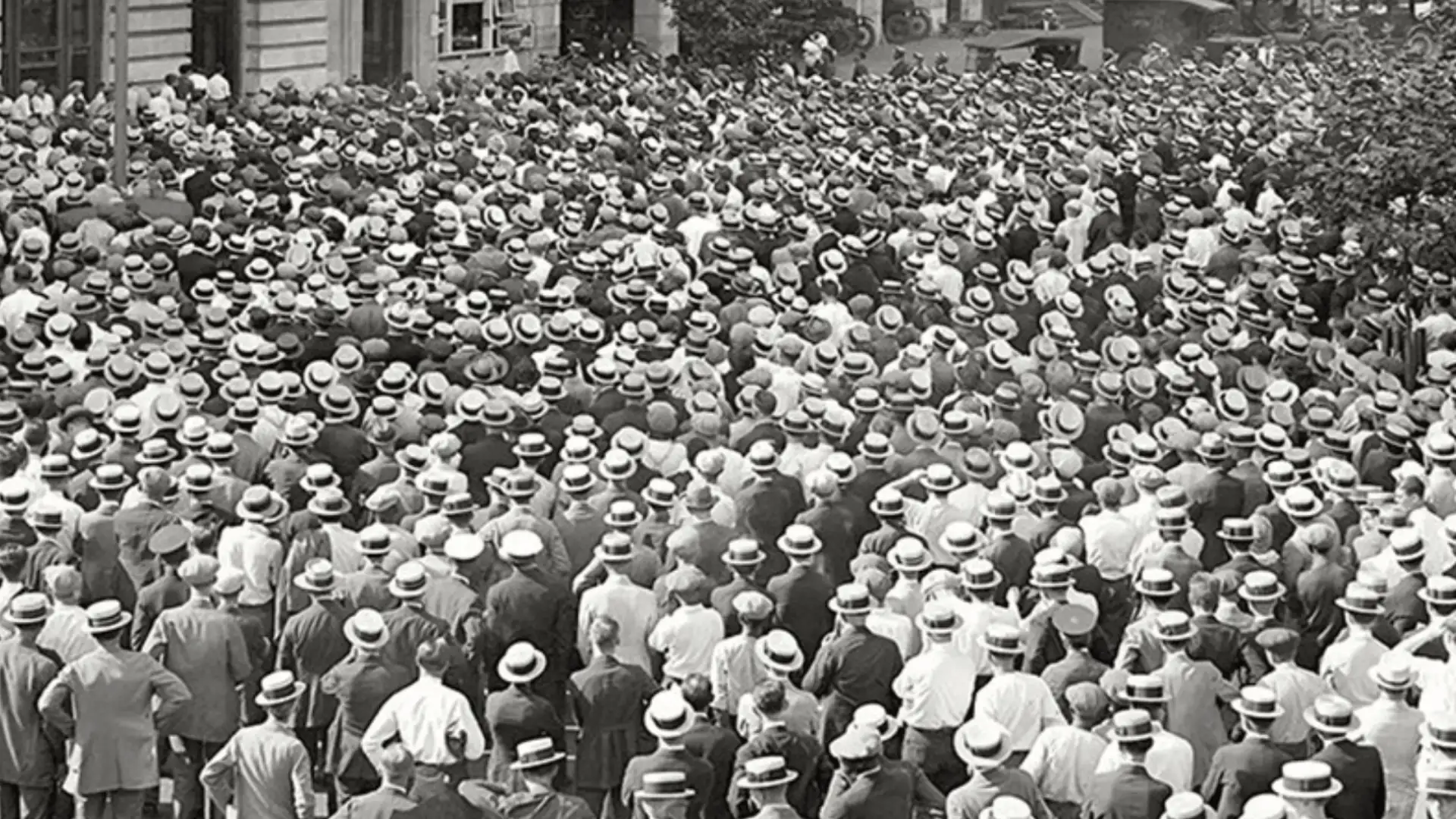 Massive crowd of men wearing straw hats gathered tightly in street during historic public unrest scene