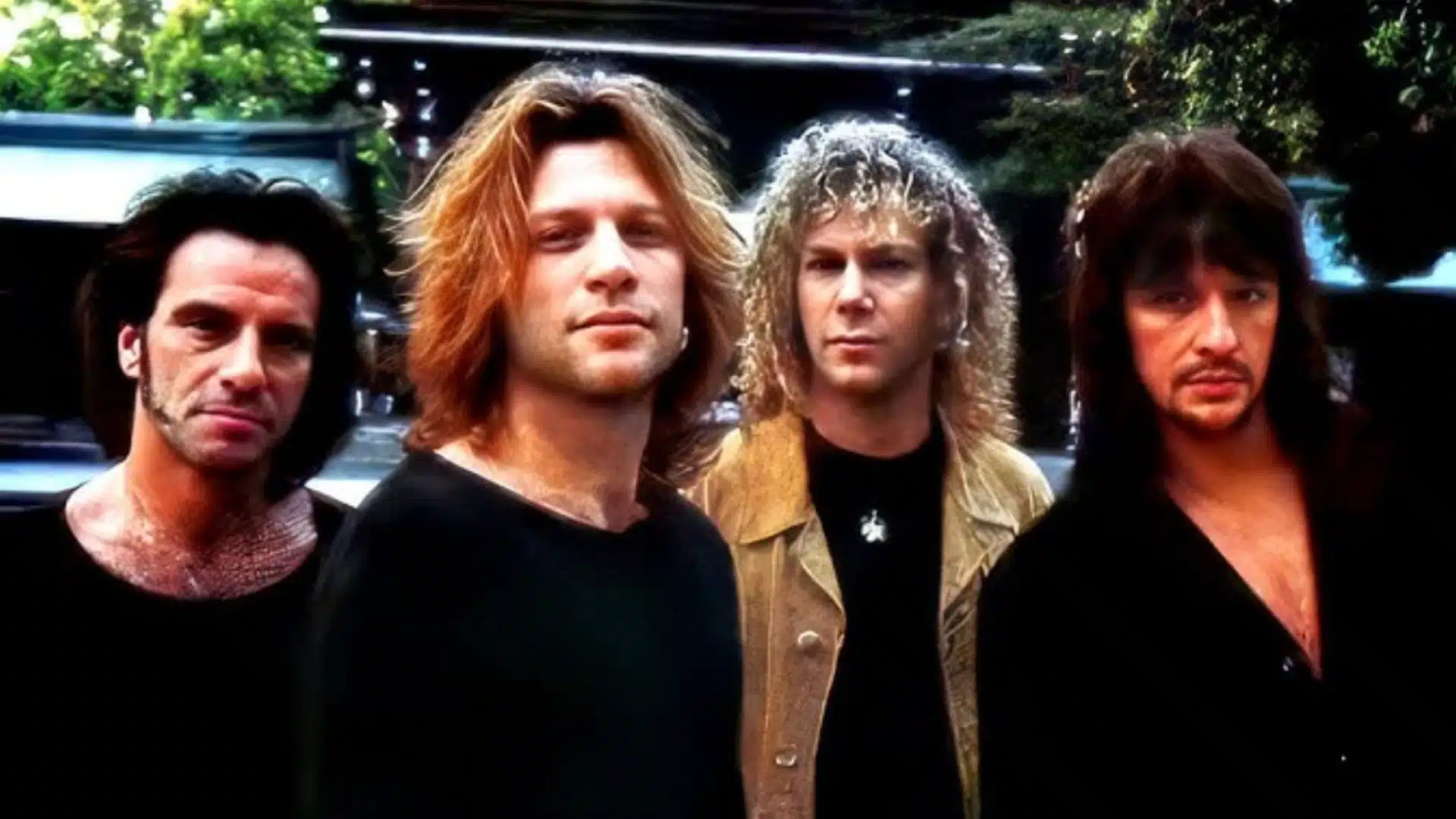 Bon Jovi band members posing together outdoors with long hair and rock style in classic promotional image