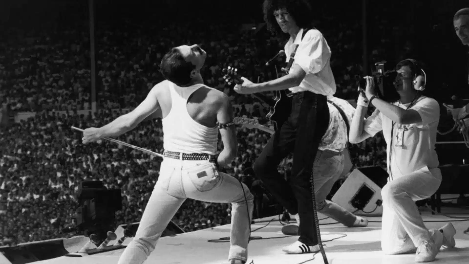 Queen performing live at Wembley Stadium during Live Aid with Freddie Mercury and band energizing huge crowd