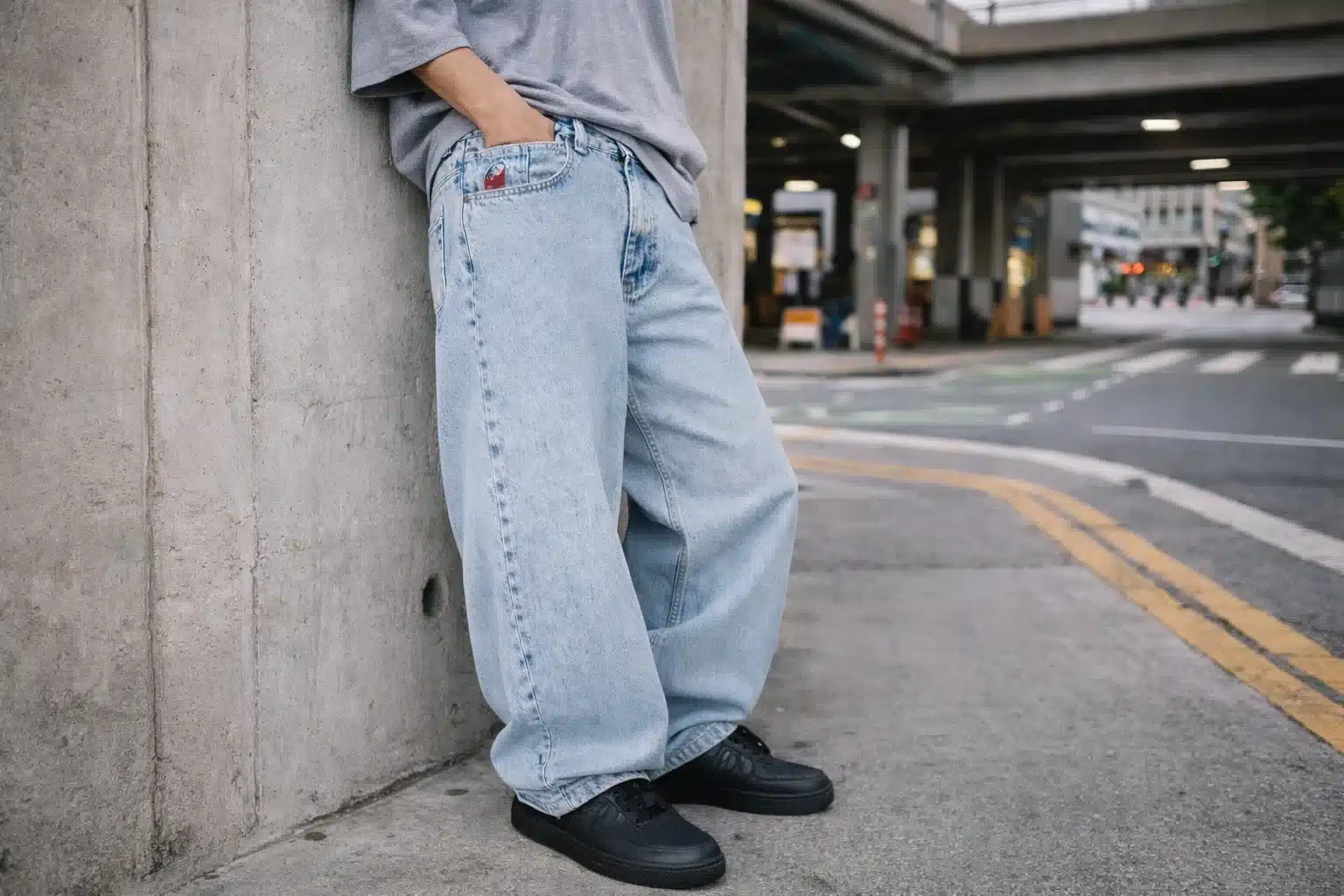 Person wearing 90s style baggy jeans with black sneakers on city street