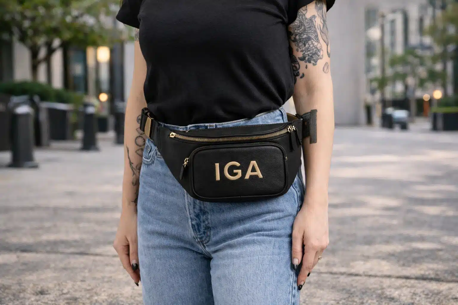 Gen Z girl wearing black crossbody fanny pack with jeans on city street