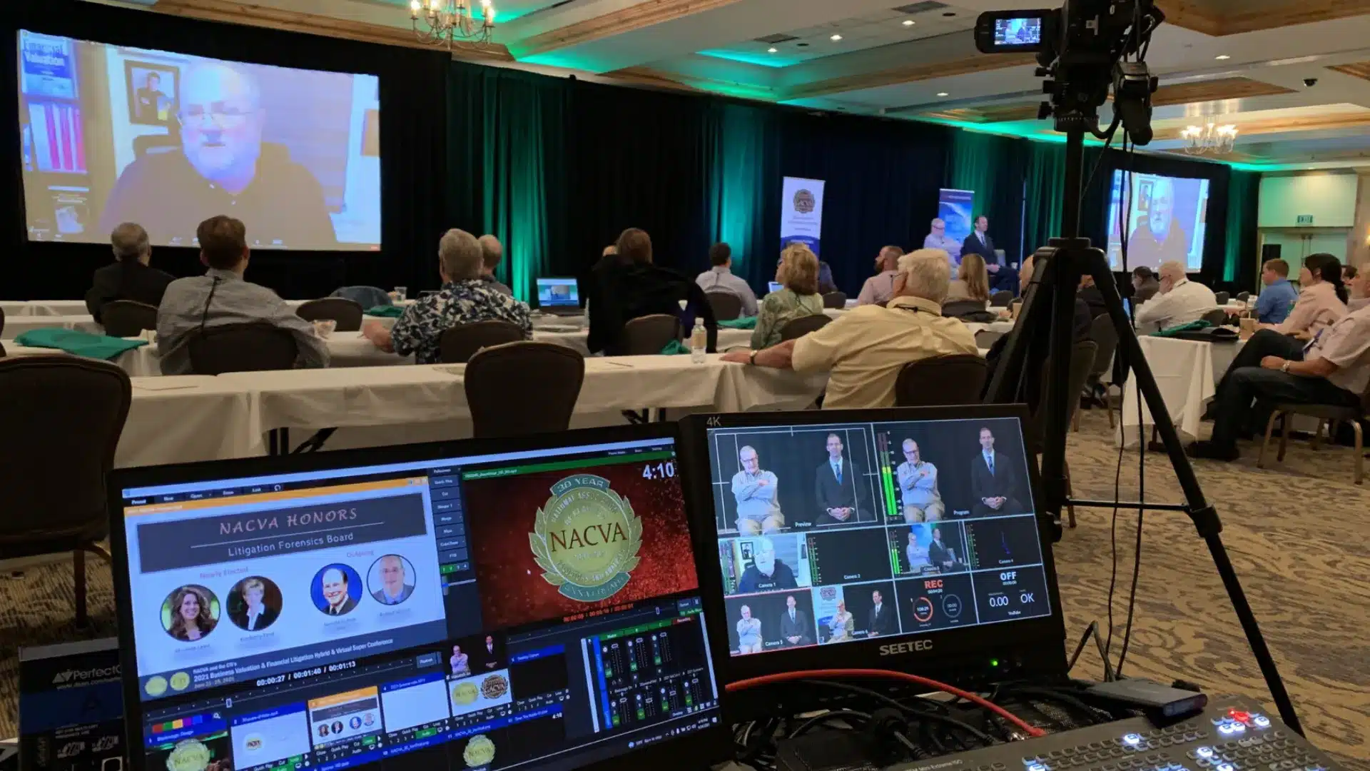 Live streaming event setup with cameras and screens capturing speaker for virtual audience viewing