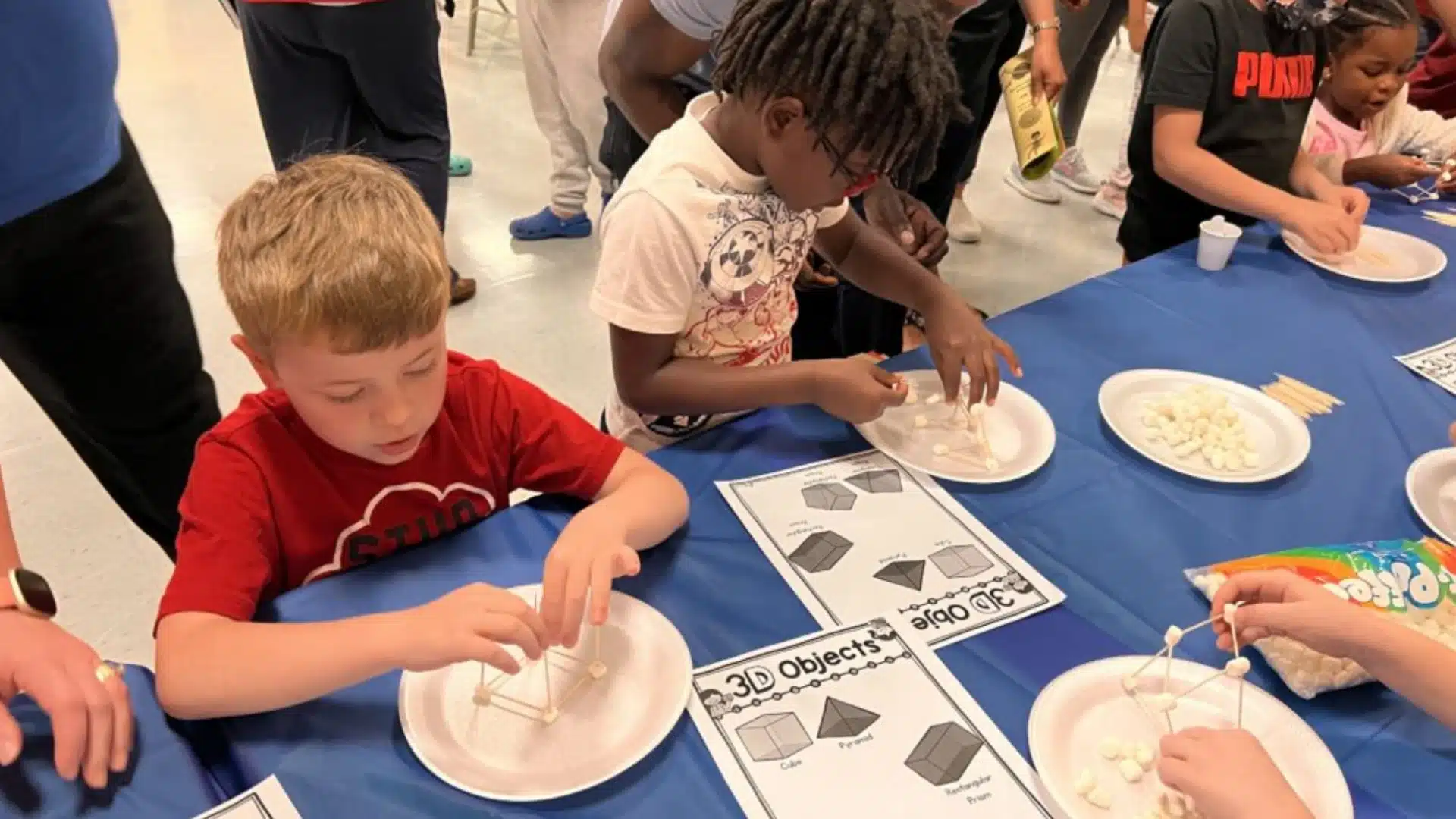 Students building 3D shapes with marshmallows and sticks during hands-on STEM learning activity at school