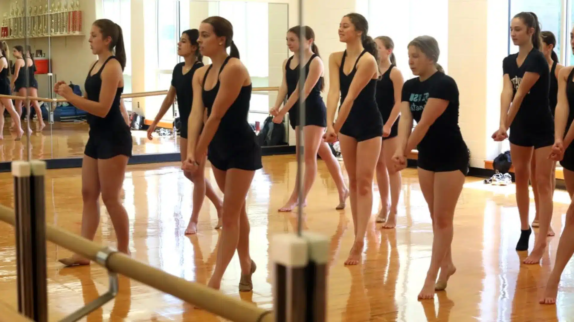 Students practicing dance routine in studio, preparing together for energetic high school dance day