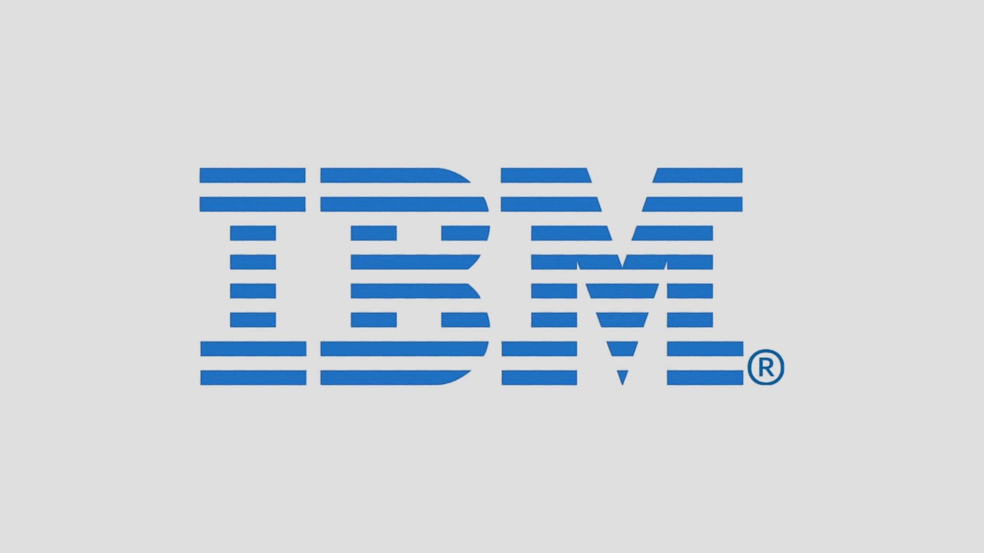 IBM logo in blue on grey background representing enterprise AI, cloud, and consulting technology services