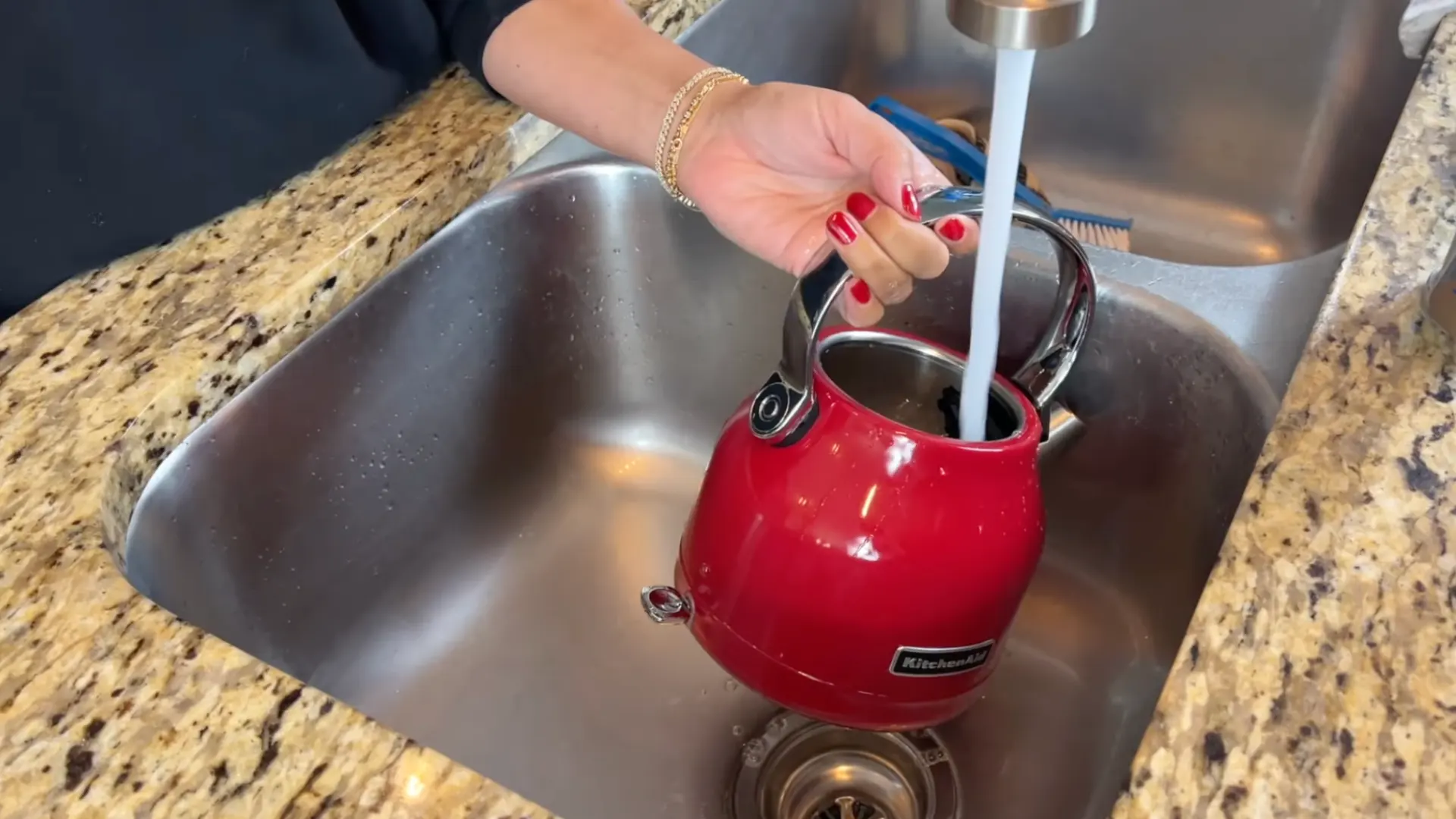Rinsing a red kettle thoroughly with clean water after descaling to remove vinegar residue