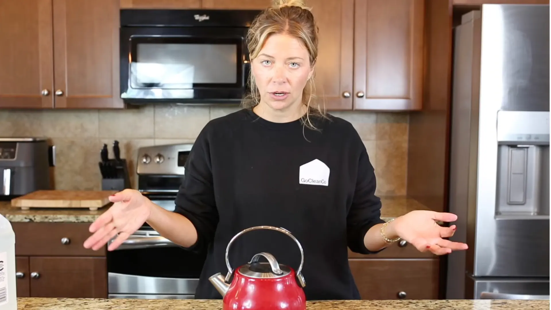 Woman explaining the kettle descaling process before boiling and soaking the vinegar mixture
