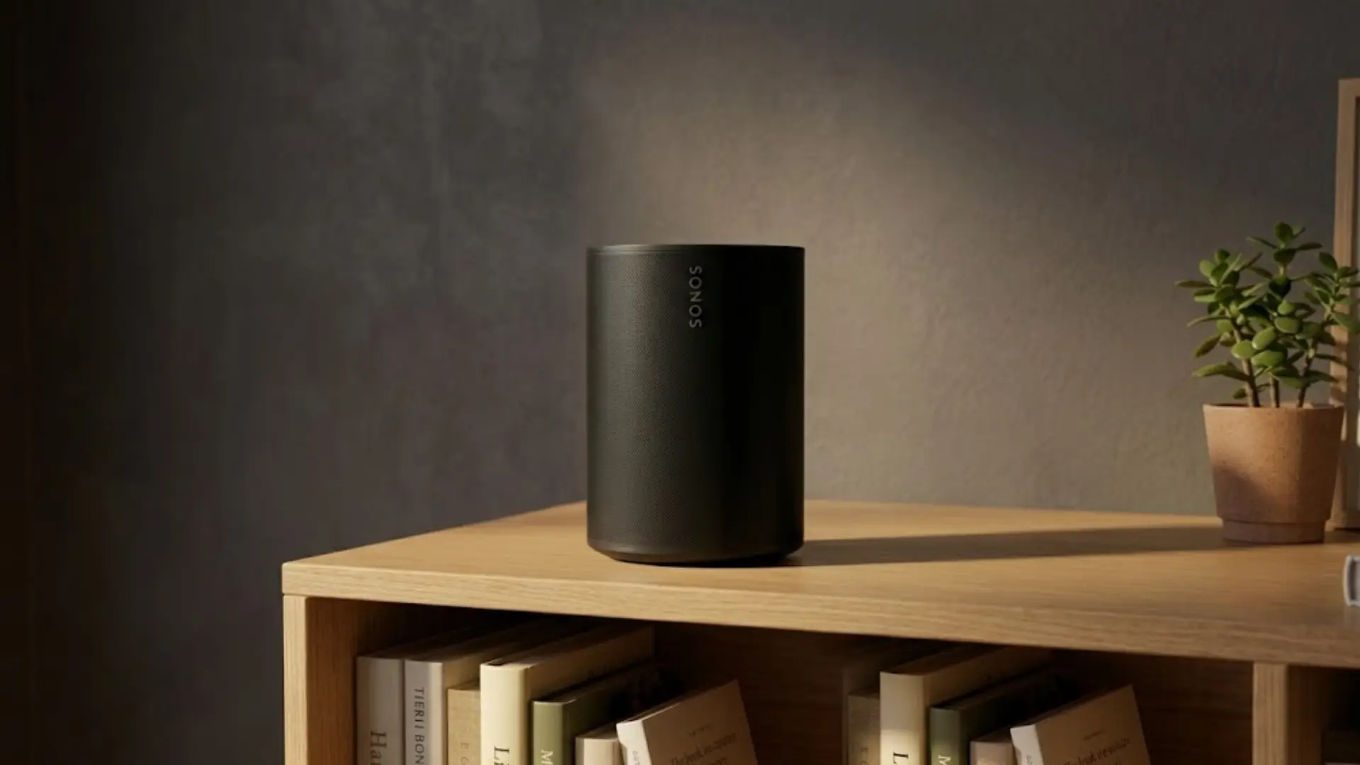 Black Sonos speaker on wooden shelf with books and plant, warm lighting, modern minimalist home interior scene