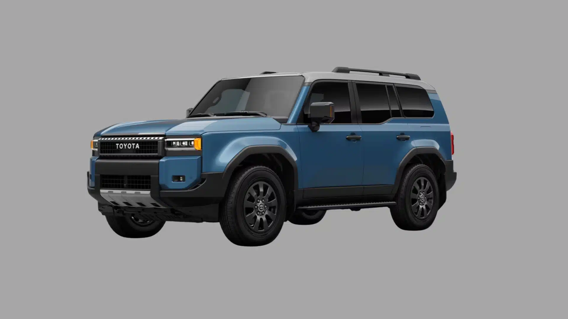 Blue Toyota SUV with a rugged boxy design, black wheels, roof rails, and gray background in studio lighting