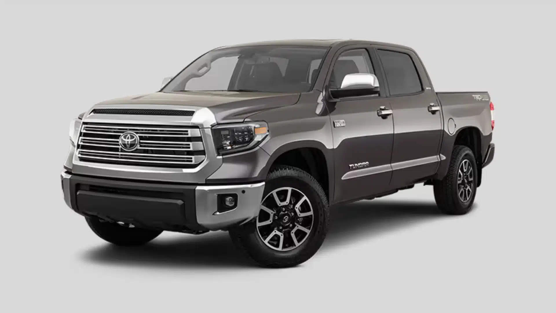 Gray Toyota Tundra pickup truck with chrome grille shown in a front side angle on a plain studio background