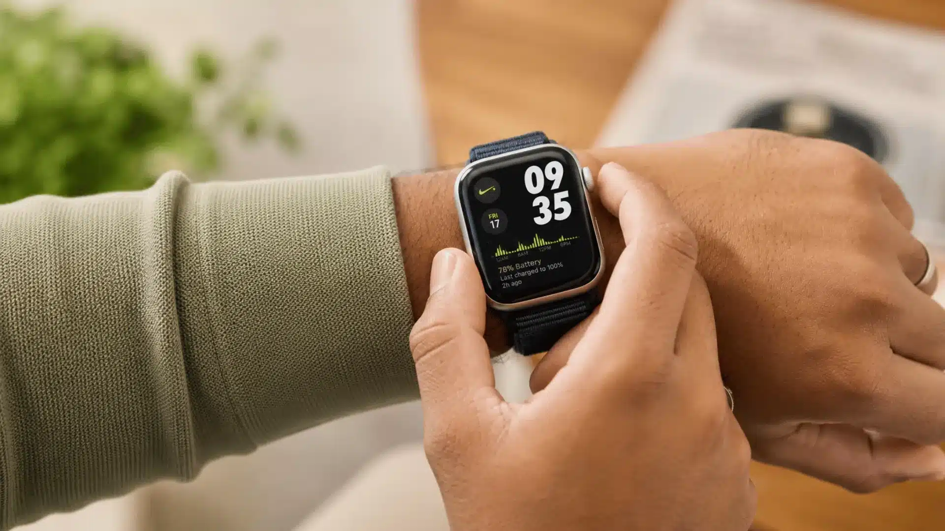 Person using a smartwatch with a custom fitness watch face indoors with blurred modern home background