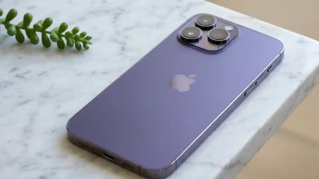 Purple iPhone 14 Pro Max lying on a marble surface with rear cameras and Apple logo clearly visible