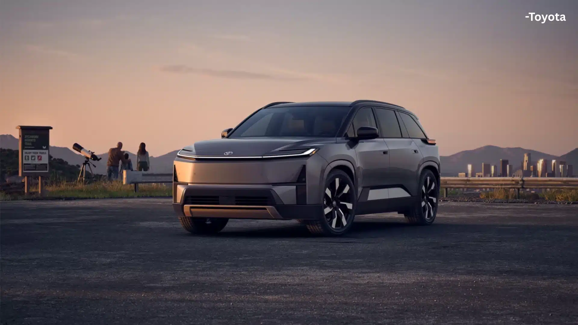 2027 Toyota Highlander SUV parked at sunset with a modern city skyline and mountain backdrop