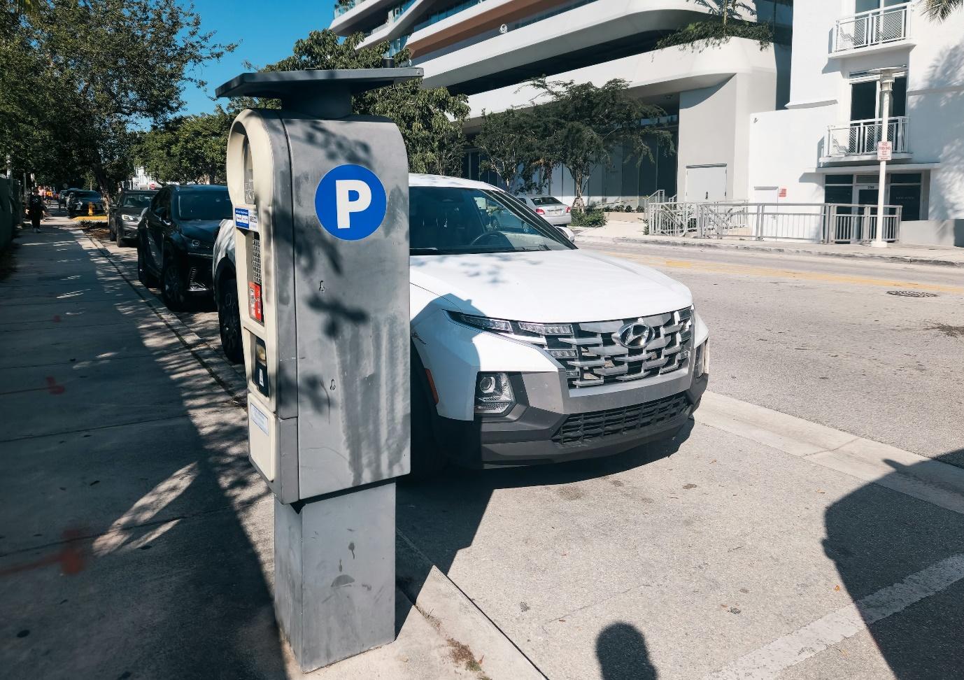 A car parked on the side of a street next to a parking meter