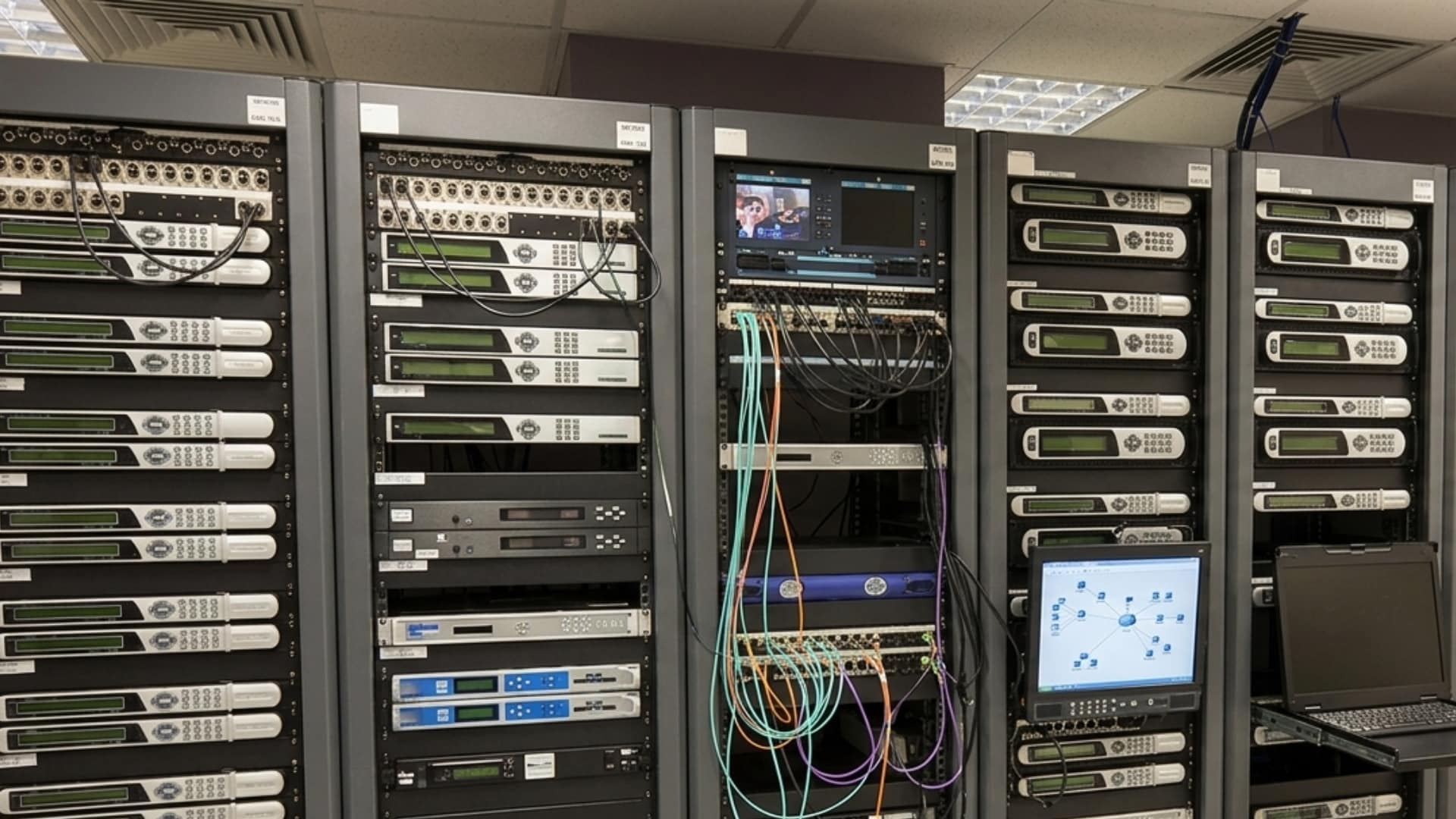 AV and network server room featuring multiple 19-inch racks filled with various equipment