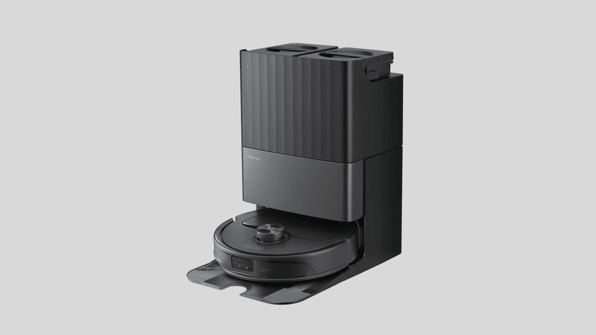 Black Roborock Q Revo Pro robot vacuum docked in its multifunction self-cleaning station on a grey background